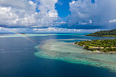  Aerial view of a rainbow on the reef near Marae Taputapuatea, Raiatea, Leeward Islands, French Polynesia, South Pacific 