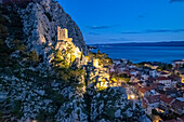 Die Altstadt von Omis mit der Ruine der Festung Mirabella oder Peovica in der Abenddämmerung von oben gesehen, Kroatien, Europa 