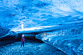 Mann in einer Eishöhle unter dem Vatnajoekull, Island