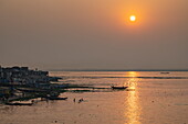 Silhouette von Fischerbooten auf dem Fluss Dakatiya bei Sonnenuntergang, Chandpur, Distrikt Chandpur, Bangladesch, Asien