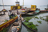 Händler verkaufen Gemüse von Booten mit Fähre dahinter, Kaukhali (Kawkhali), Distrikt Pirojpur, Bangladesch, Asien