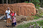 Einheimische Familie vor riesigen Mengen an Keramiktöpfen  in der Töpferkolonie Kumar Pada, Kaukhali (Kawkhali), Distrikt Pirojpur, Bangladesch, Asien