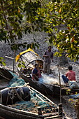 Einheimische reparieren Fischernetze auf einem Boot, Pakhiralay, bei Gosaba, South 24 Parganas District, Westbengalen, Indien, Asien