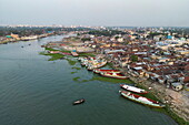 Aerial of fishing boats moored alongside Dakatiya river with river cruise ship RV Thurgau Ganga Vilas (Thurgau Travel) in distance, Chandpur, Chandpur District, Bangladesh, Asia