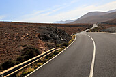 Tarmac road crossing barren desert mountainous land between Pajara and La Pared, Fuerteventura, Canary Islands, Spain