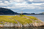 Monument marker to show crossing the Arctic Circle heading south on small  island, Norway