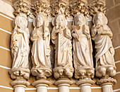 Historic Roman Catholic cathedral church of Évora, Sé de Évora, in the city centre, Basilica Cathedral of Our Lady of Assumption. This image shows details of the carved Gothic period Apostles in the main doorway entrance. Marble columns are occupied by huge statues of the Apostles dating from the 1330s.
