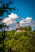  View of the Fuchsturm on the local mountain in Jena in summer with blue sky and white cumulus clouds, Jena, Thuringia, Germany 