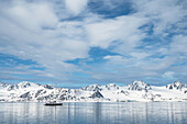 Boot vor schneebeckten Bergen auf Spitzbergen, Spitzbergen, Svalbard, Norwegen, Arktis