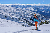  Woman on ski tour ascending to Speikspitze, Zillertal Alps in the background, Speikspitze, Kitzbühel Alps, Tyrol, Austria 