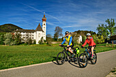 Mann und Frau fahren mit dem Rad am Kloster Höglwörth vorüber, Höglwörth, Bodensee-Königssee-Radweg, Oberbayern, Bayern, Deutschland