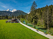 Mann und Frau fahren mit dem Rad entlang der Ramsauer Ache am Bodensee-Königssee-Radweg, Watzmann im Hintergrund, Berchtesgaden, Oberbayern, Bayern, Deutschland