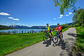 Mann und Frau auf dem Bodensee-Königssee-Radweg fahren am Tegernsee entlang, Tegernsee, Oberbayern, Bayern, Deutschland