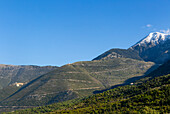 Snow capped peak of Mount Cika and mountain road over Llogara Pass, Palase, near Dhermi, Albania