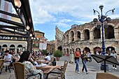 Menschen im Straßencafe an der Arena von Verona, Veneto, Italien