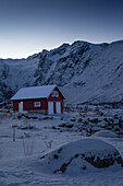  Winter in the Trömso region, Tromvik, typical traditional house with mountains in the twilight 