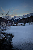  Mountain village Tschierv, Graubünden, Valmüstair, Switzerland, in winter with alpenglow. 