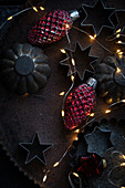  Old cookie cutters on tin with old Christmas tree decorations and fairy lights 