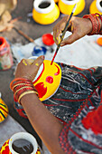 Pune, India Lady painting pots for Indian celebration Diwali