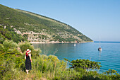  Frau beobachtet eine Bucht der Halbinsel Karaburun im Karaburun-Sazan Marine Park, Bucht von Vlore, Albanien, Südosteuropa 