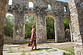 Young woman inside the Remains of the Grand Basilica, Archaeological site of Butrint, Butrint National Park, UNESCO World Heritage Site, near Saranda, on the Ionian coast, Albania, Southeastern Europe