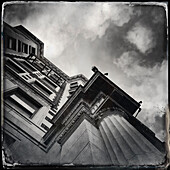 Old urban building exterior, low angle view against sky and clouds