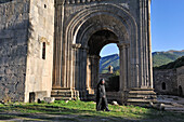 priest in front of the narthex of Sts. Paul and Peter Church, Tatev monastery, Syunik Province in southeastern Armenia, Eurasia