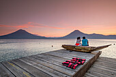 Tourists on a mooring enjoying the sunset, Lake Atitlan and San Pedro volcano, Santiago Atitlan, Sololá department, Guatemala, Central America