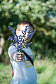 Nice boy with flowers in the hands in summer forest