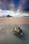  Beach with stone in the water. In the background La Rocco Tower stands in the sea. 