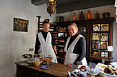 Museum staff members dress up in historical authentic clothing at Den Gamle By or The Old Town, open air town museum that consists of 75 historical buildings collected from 20 townships in all parts of the country (originally erected between 17th and 20th century), Aarhus, Jutland Peninsula, Denmark, Northern Europe