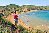 young woman admiring the Cavalleria Beach at Cape Cavalleria on the North Coast of Menorca, Balearic Islands, Spain, Europe