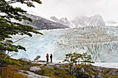 Männer beobachten den Pia-Gletscher, Cordillera Darwin, Beagle-Kanal (nordöstlicher Zweig), Feuerland, Patagonien, Chile, Südamerika