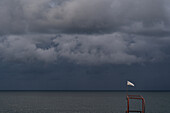 Weiße Flagge auf dem Wachturm am Strand bei Sturm, Schwarzes Meer, Georgien, Vorderasien