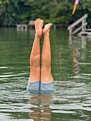  Young man doing handstand in Wörthsee, Bavaria, Germany in July 2024 