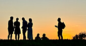  Silhouette of a group of people at sunset in the Olympic Park in Munich in July 2024 