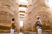 Junge Frauen in der großen Hypostyle-Halle im Bezirk Amon-Re, Karnak-Tempel-Komplex, Luxor, Ägypten, Nordostafrika