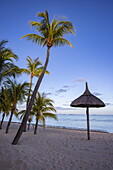 Kokospalmen und Strohschirme am Strand im Dinarobin Beachcomber Golf Resort & Spa, Le Morne, Rivière Noire, Insel Mauritius, Indischer Ozean