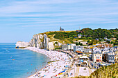  Etretat and chalk cliffs with beach and rock arch La Falasie d&#39;Aumont at high tide in Etretat (Étretat) on the Alabaster Coast (Côte d&#39;Albâtre, Cote d&#39;Albatre) in the Seine-Maritime department in the Normandy region of France 