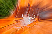 Radial blur of a woman screaming on a waterslide in the Acqua Plus Water Park. Crete, Greece.