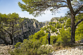  Woman standing on the limestone cliffs in the Calanques National Park between Cassis and Marseille, Provence, France, Europe 