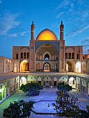 Blick auf die Agha-Bozorg-Moschee aus dem 18. Jahrhundert und Innenhof, beleuchtet in der Abenddämmerung. Kashan, Iran.