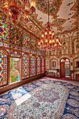 Interior view of the shahneshin (a dedicated reception room) with large colorful stained glass windows in Mollabashi Historical House in Isfahan, Iran.