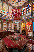 Ornate interior of a small room with stained glass windows in the Mollabashi Historical House. Isfahan, Iran.