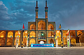 Takyeh (Gebäude, in dem sich schiitische Muslime versammeln, um Husayns Tod zu betrauern) und Minarette des Amir-Chakhmaq-Komplex, nachts beleuchtet. Yazd, Iran.