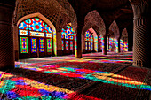 A play of light from multi-colored stained-glass windows inside the 19th century Nasir al-Mulk Mosque, aka the Pink Mosque. Shiraz, Iran.