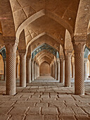  Innenansicht der zentralen Gebetshalle mit vielen Säulen, die das Dach der Backsteingewölbe in der Vakil-Moschee aus dem 18. Jahrhundert in Shiraz, Iran, stützen. 