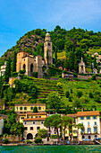 Haus und Kirche auf einer Bergkette an einem sonnigen Sommertag am Ufer, Luganersee in Morcote, Lugano, Tessin, Schweiz.