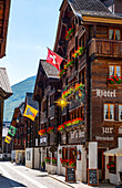 Beautiful City Street in Old Town with Houses and Hotel and with Mountain in a Sunny Summer Day in Andermatt, Uri, Switzerland.