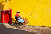 Cycle rickshaw rides in Ketandan Wetan street. Yogyakarta, Java, Indonesia.